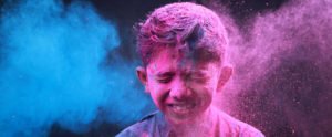 A boy closed eyes to prevent Holi colors falling in
