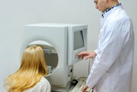 A young woman is taking perimetry test